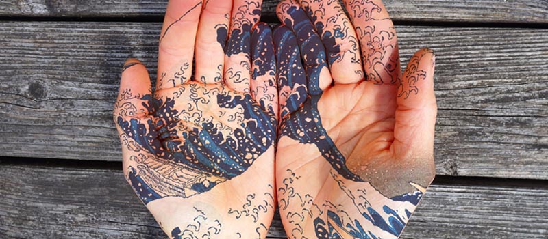 Image by Toni Davey of Tattooed hands featuring Hokusai’s iconic woodcut, ‘The Great Wave of Kanagawa’.