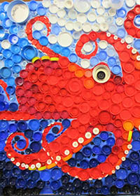 yo19-charlie-matthews Red and orange octopus swimming in the ocean, made from plastic bottle tops.