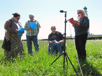 jane-pitt 4 people in a field with a microphone and scripts